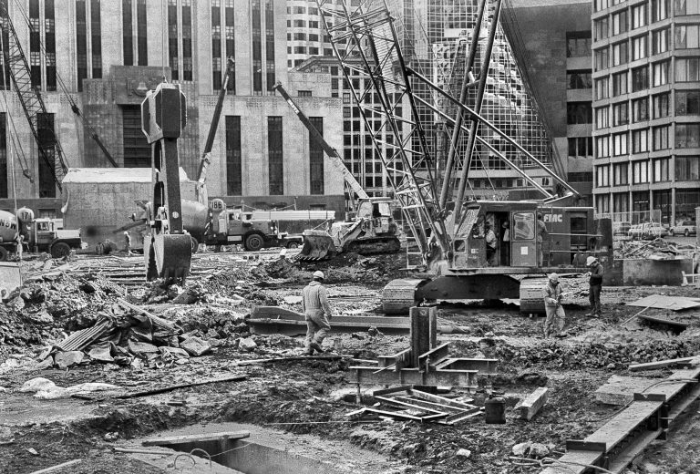 Unrecognizable workers on industrial construction in city